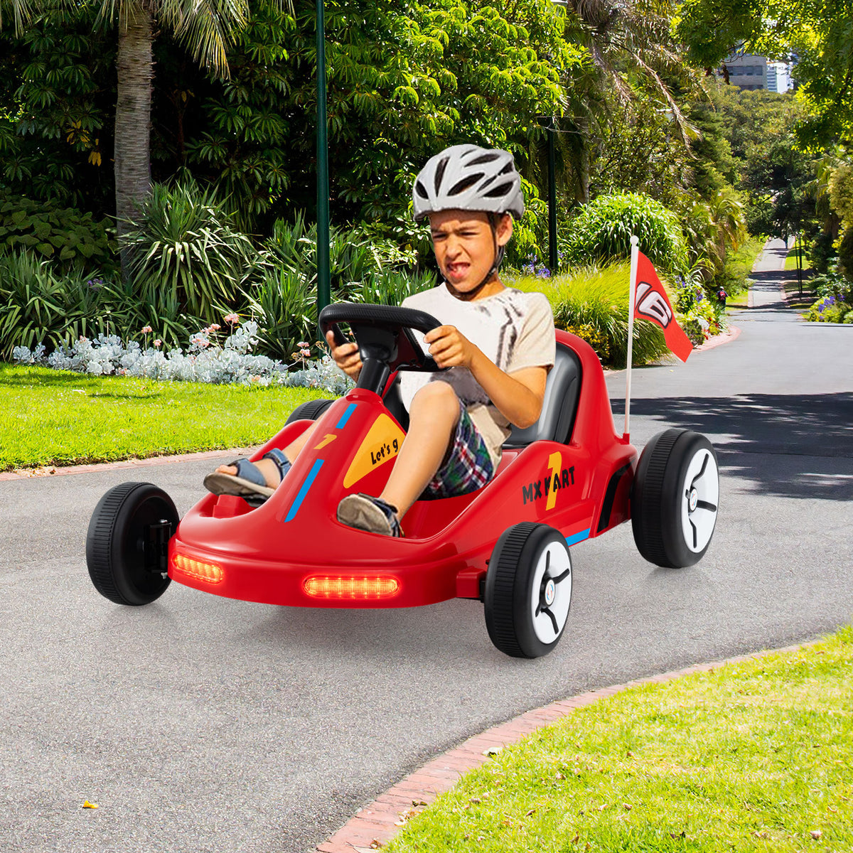 the kids electric car being driven by a young boy on a sunny outdoor driveway