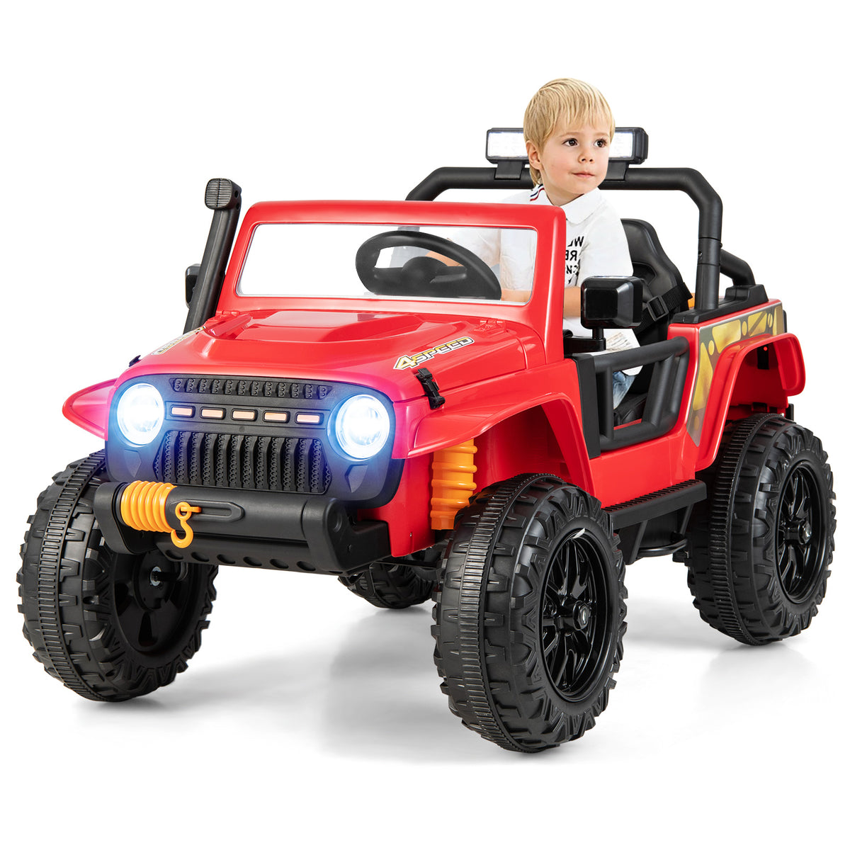 A young boy sits in the red kids electric car on a path