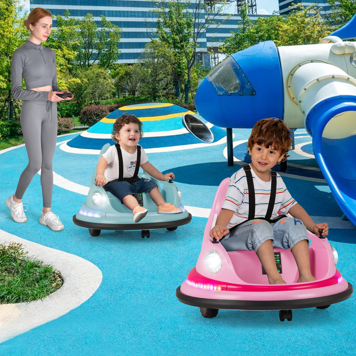A woman watching two children ride the pink and blue kids electric cars in a playground