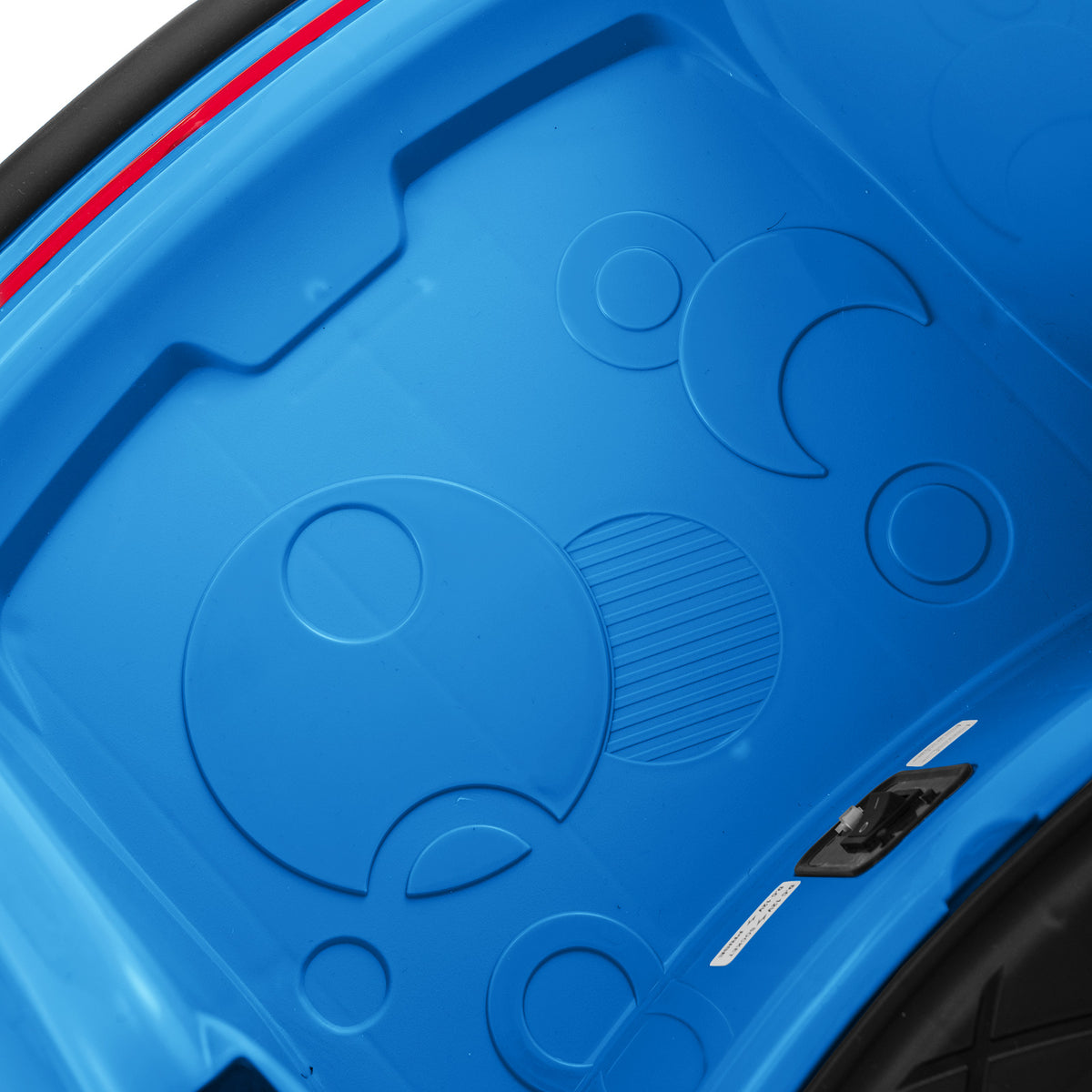 The navy blue floor area inside the kids electric car featuring embossed circular patterns