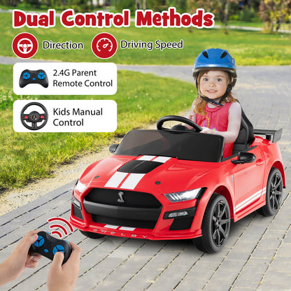 The kids electric car being driven by a child while a parent uses the remote control