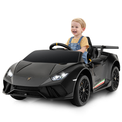 A happy child sits in the black kids electric car Lamborghini on a paved surface
