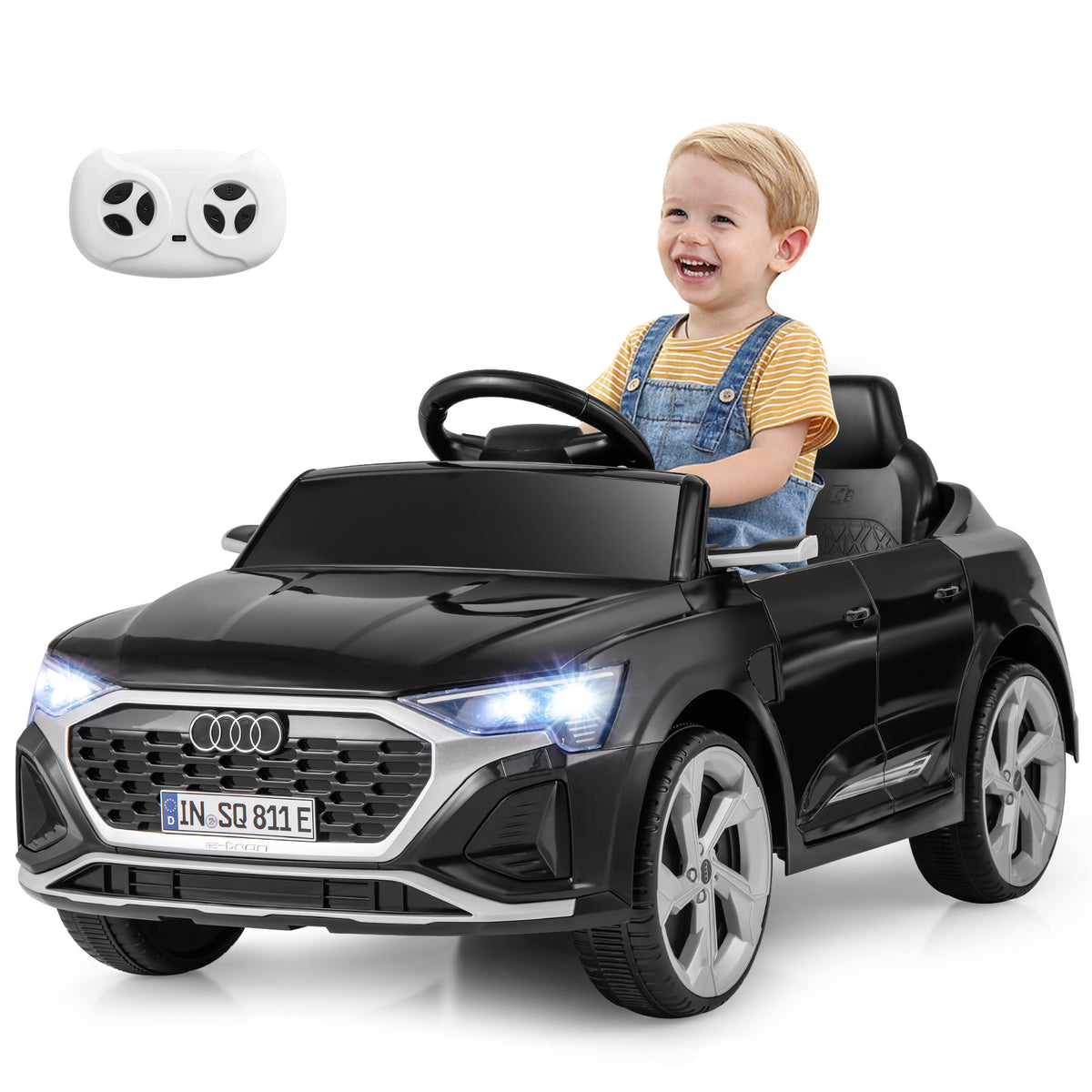 A happy toddler sits in the black kids electric car, with a remote control shown above