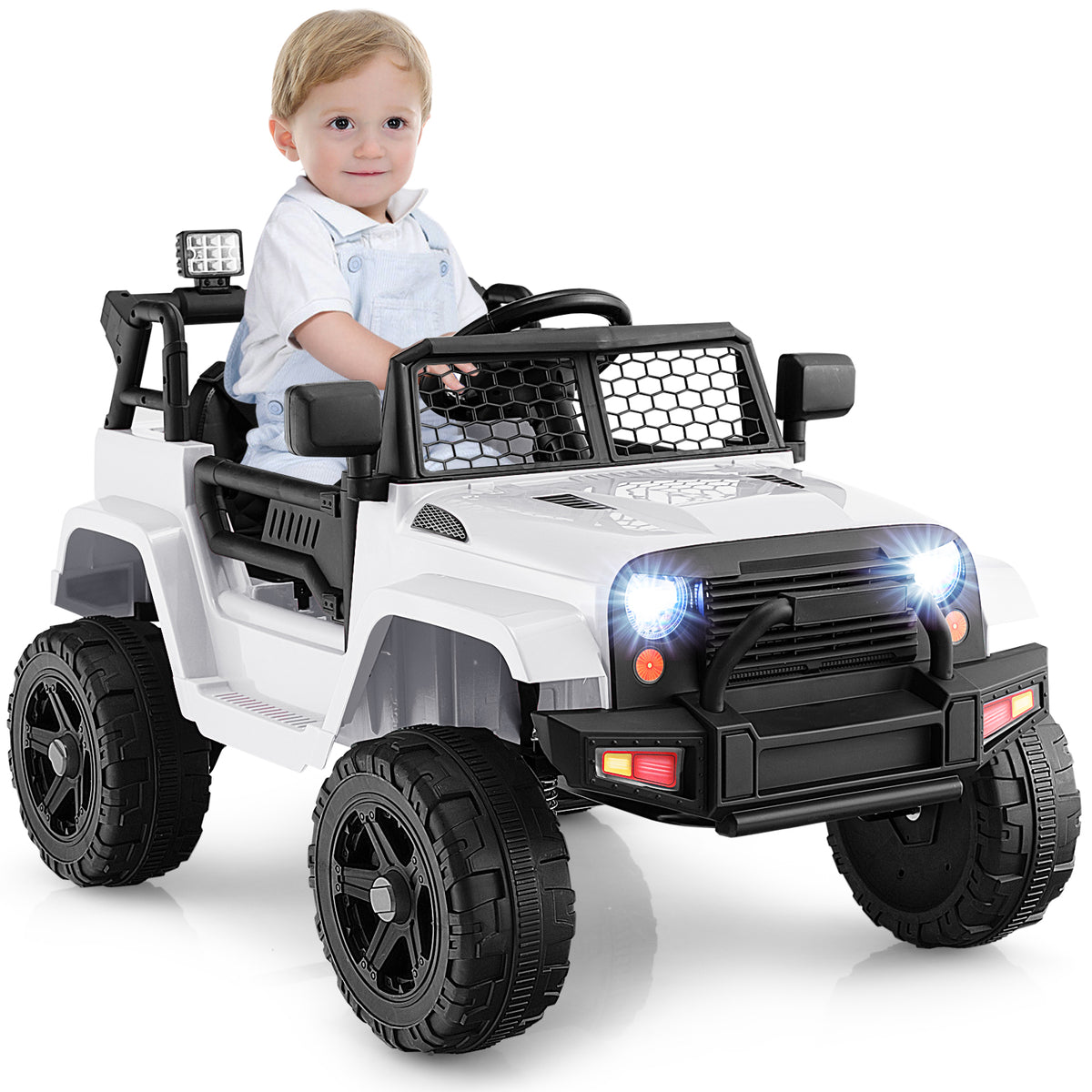 A toddler enjoys a ride in the white kids electric car on a sunny day