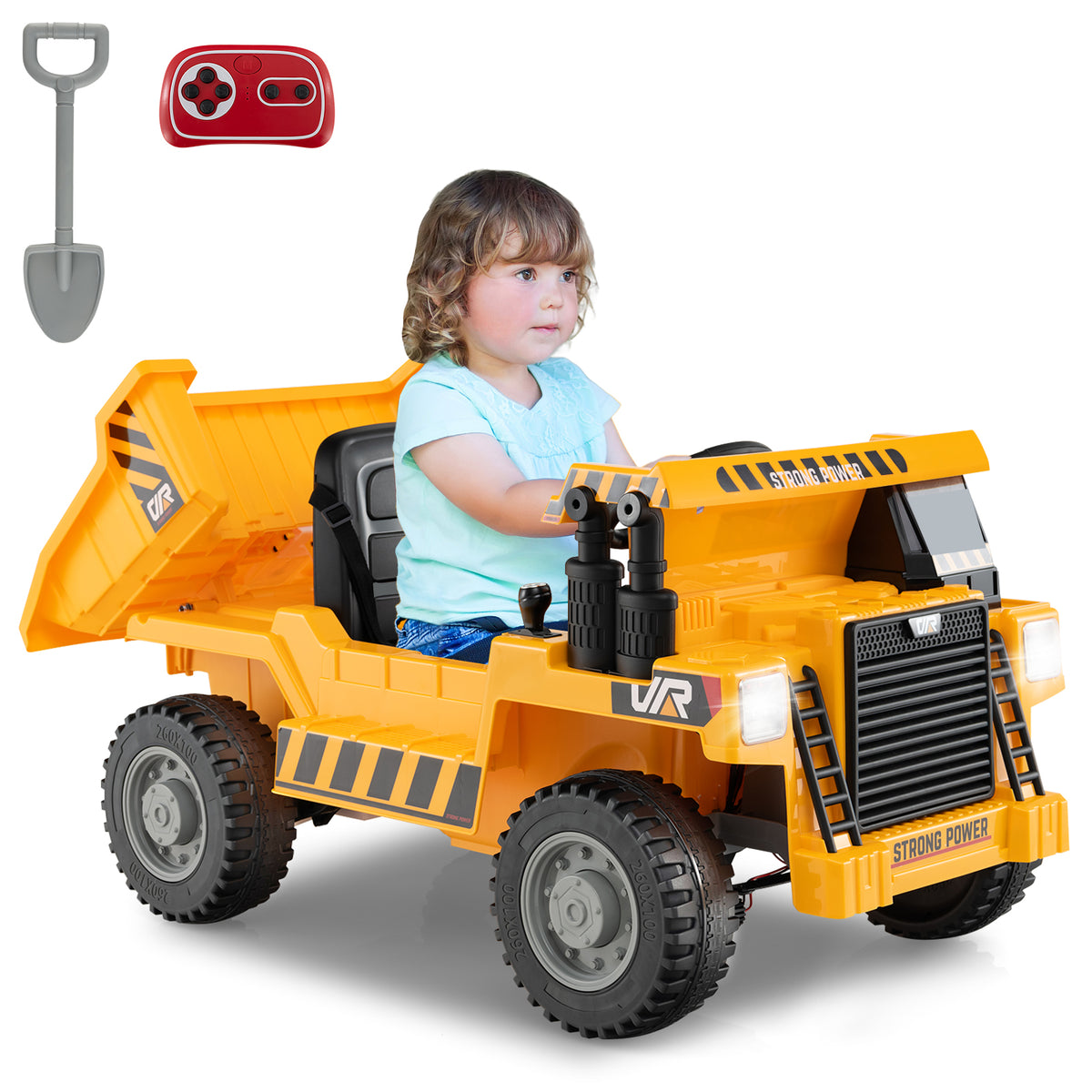 A young child sits in a yellow electric dump truck, with a remote control and shovel nearby