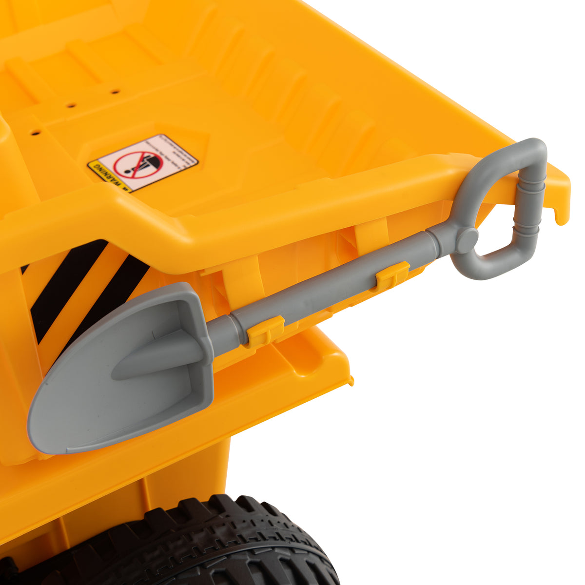Close-up of a grey plastic shovel attached to the side of a yellow electric dump truck