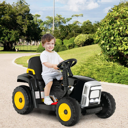 A young boy sitting on the kids electric tractor without the trailer on a paved park path