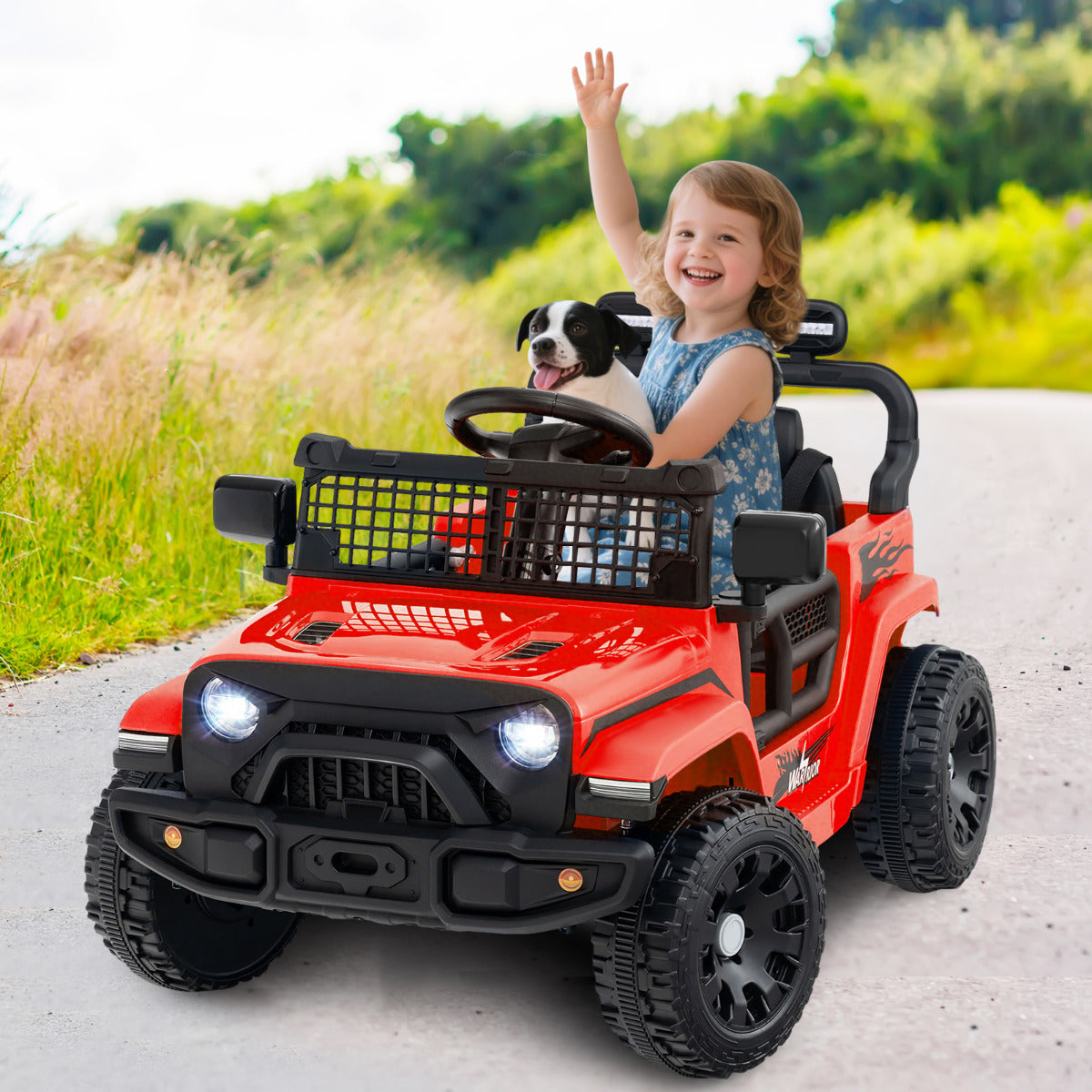 A red kids ride on truck car with a child and a dog in it, driving on a path