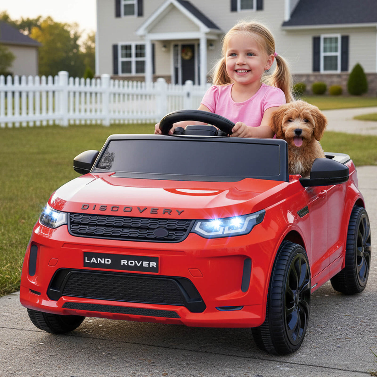 The red electric ride on car with a child and a puppy inside, parked on a driveway