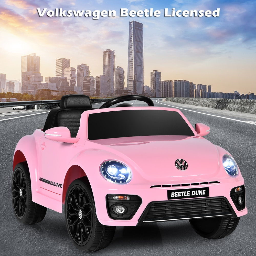 Pink electric ride on car parked on a road with a city skyline behind