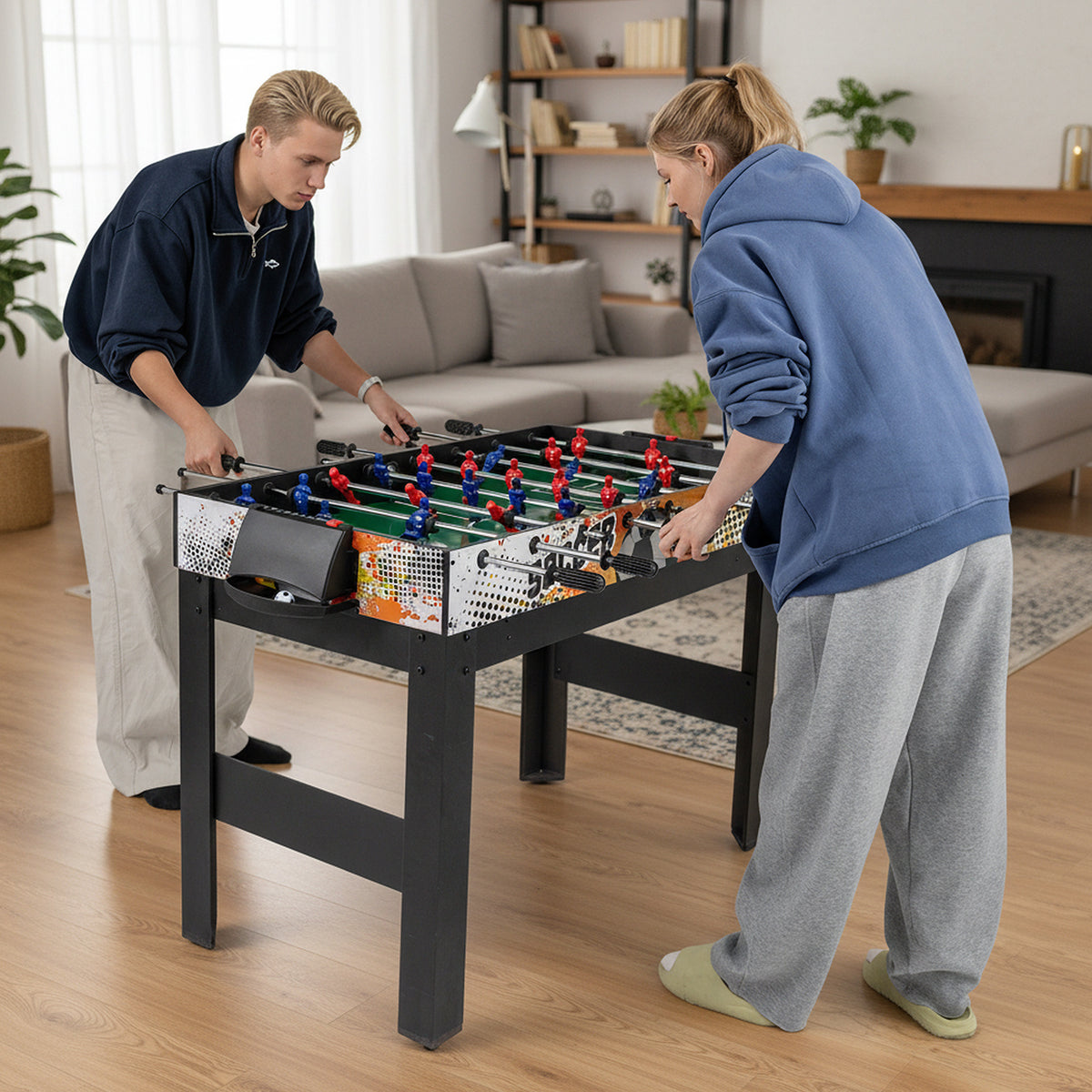 Two young people playing foosball on the multi-game table in a living room setting