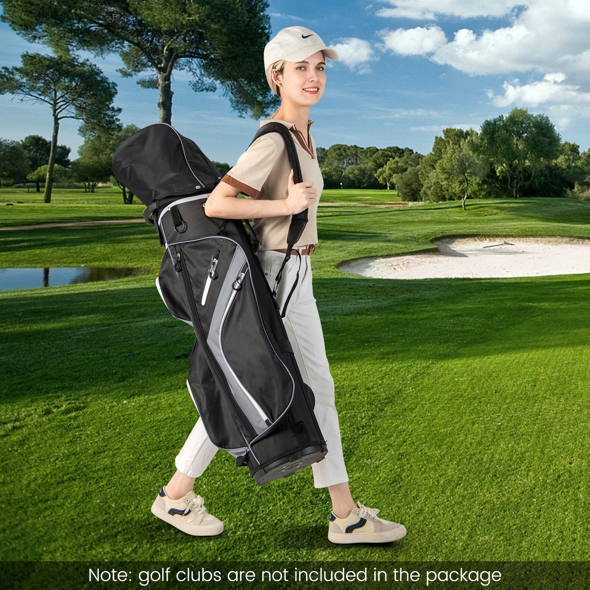 Woman carrying the grey golf cart bag across a golf course