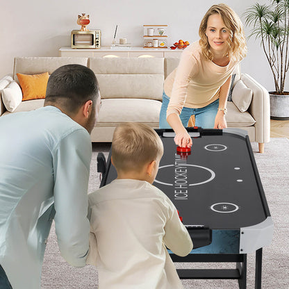 A family playing the air hockey table together in a bright room