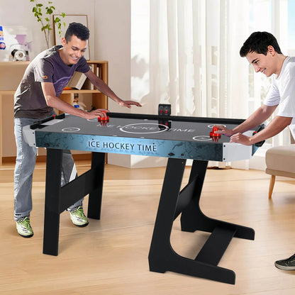 Two men playing the foldable air hockey table in a living room setting