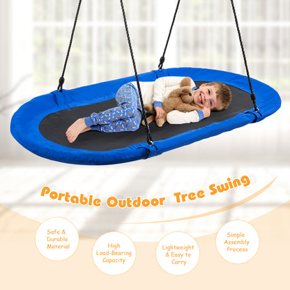 A young boy lying on the oval swing with a soft toy in a bright indoor room