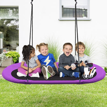 Four children sit on the oval swing in a garden setting