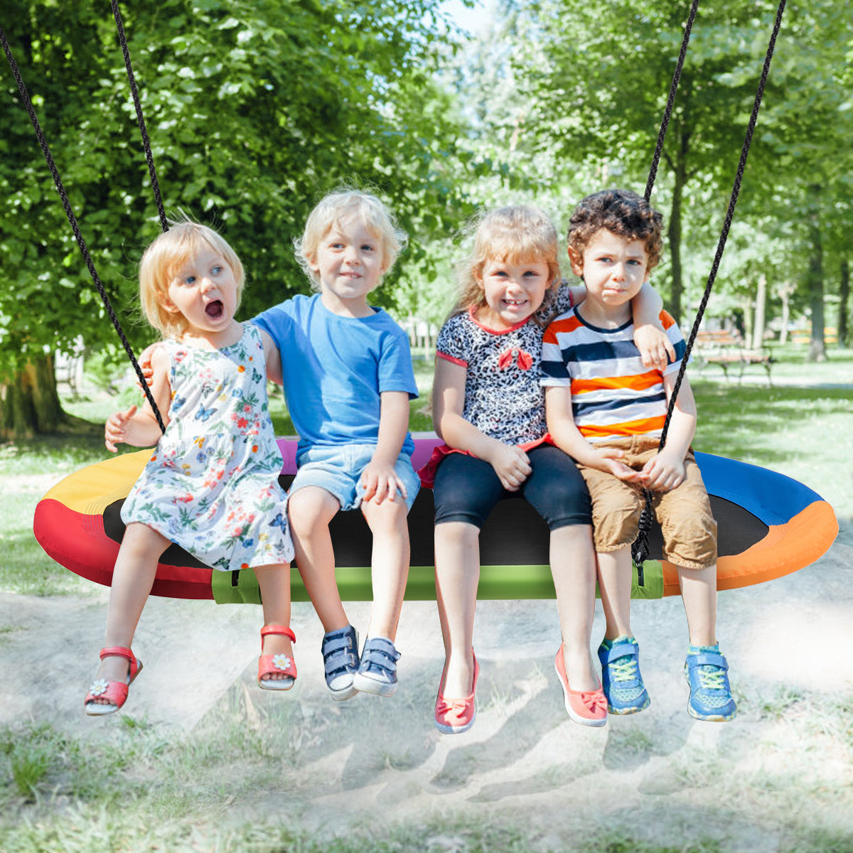 Four children sitting on the oval swing in a park setting