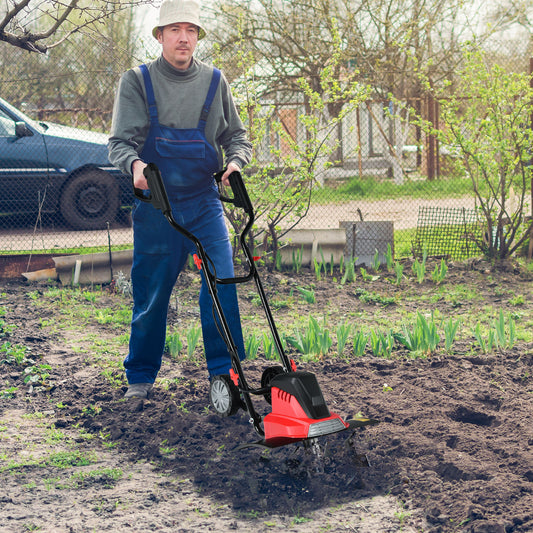 the garden tiller being used by a man to cultivate soil in a vegetable patch