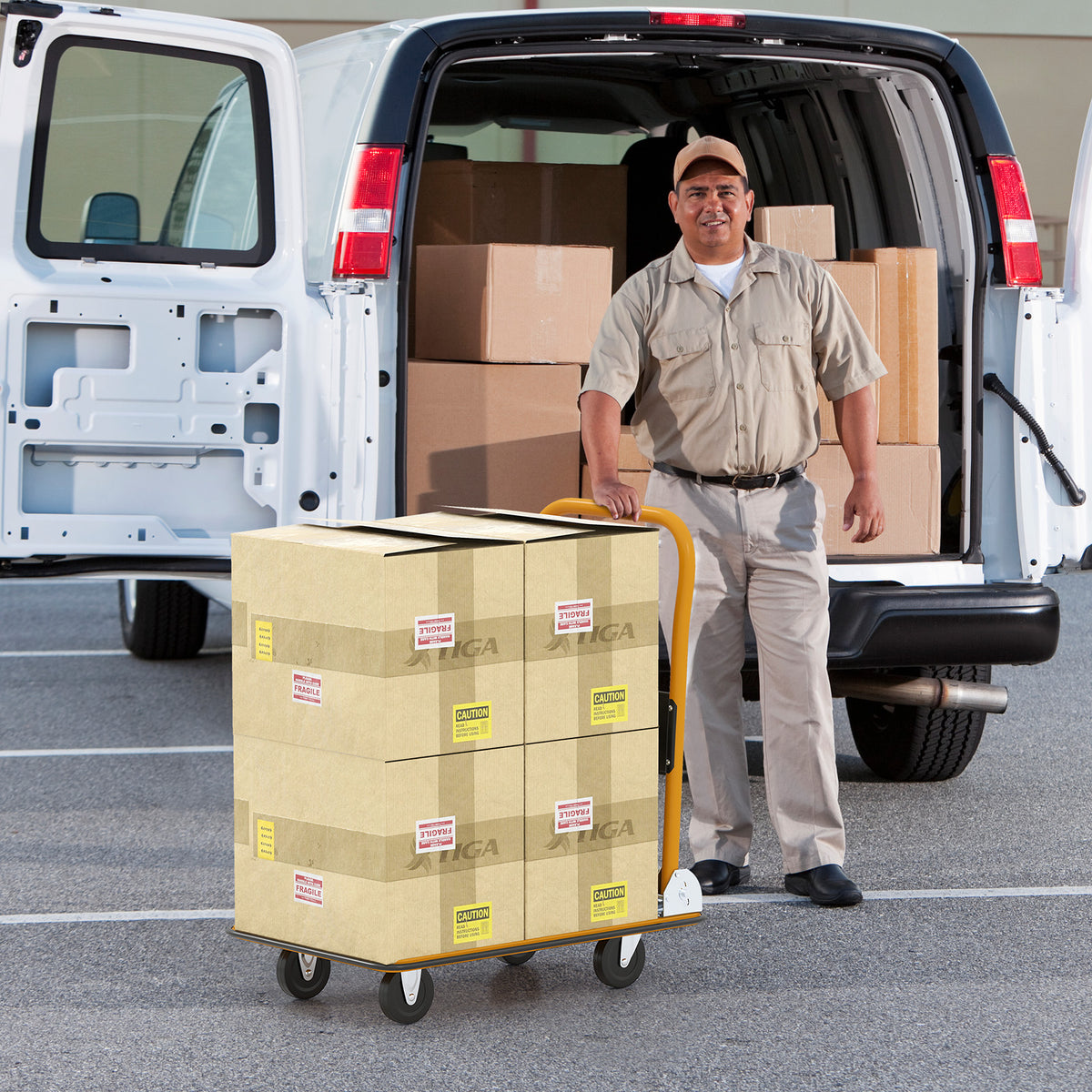the push cart loaded with cardboard boxes being moved by a man near a delivery van