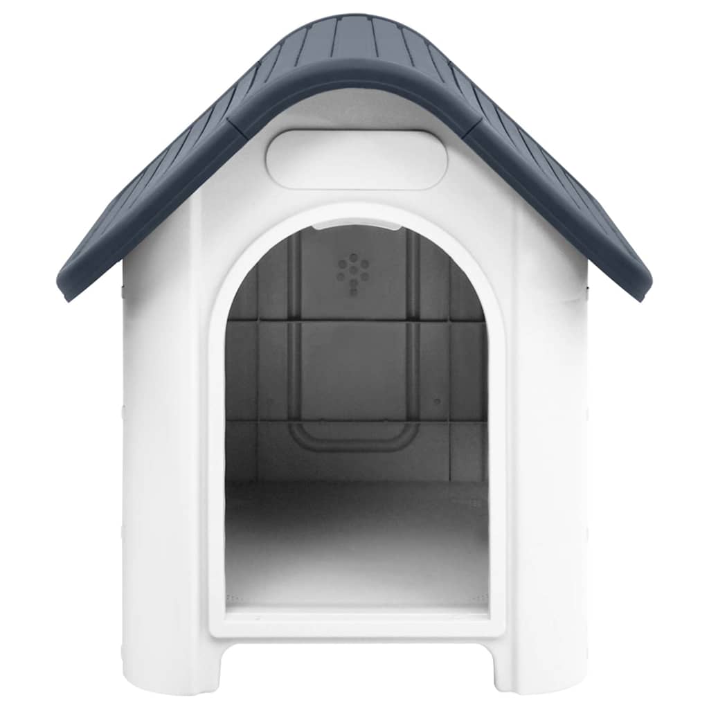 The dog house shows its pitched roof and open doorway with white walls