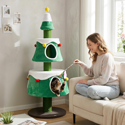 A woman playing with a cat on a green cat Christmas tree with two condos