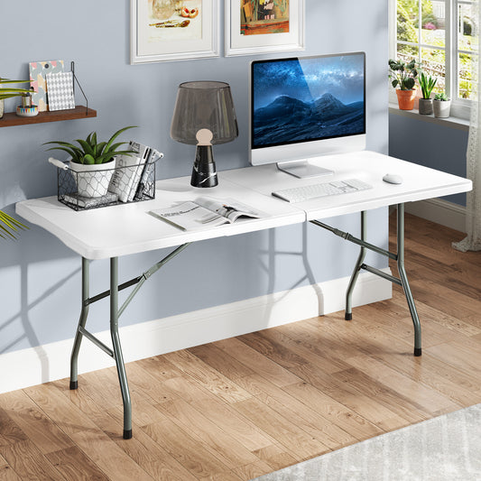 The patio table set up as a home office desk with a computer and lamp in a bright room