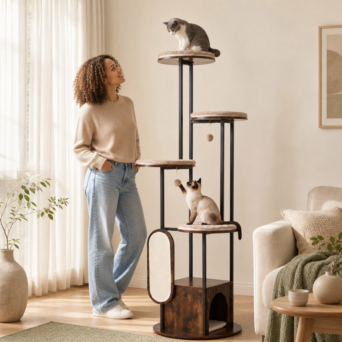 A woman stands next to the modern cat tree tower with two cats interacting with it