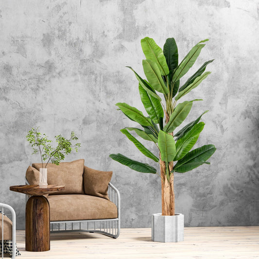 The artificial banana tree with large green leaves and a textured trunk in a concrete pot