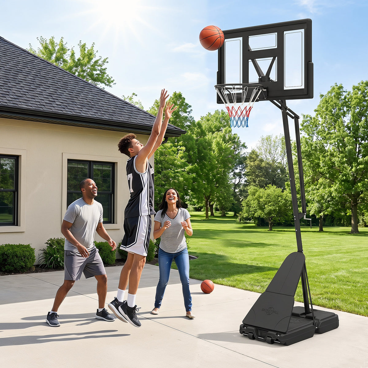 A family playing basketball on a driveway with the adjustable hoop