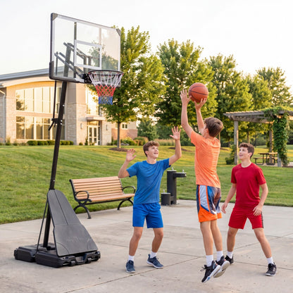 Three boys playing basketball with the portable hoop outdoors