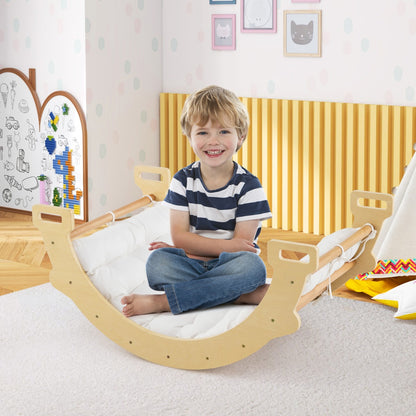 Smiling boy sitting on the natural wood arch rocker with white cushion in a nursery
