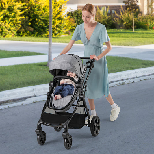 A woman pushes a baby stroller with a baby inside on a paved path outdoors