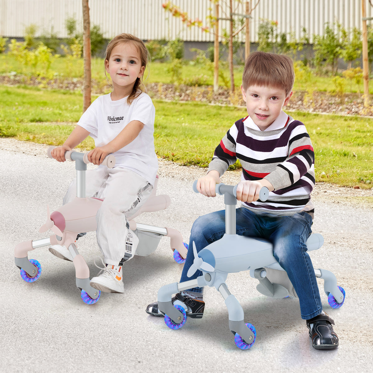 Two children riding on pink and blue ride-on push cars with lighted wheels