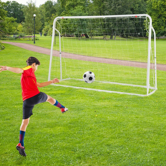Kids soccer rebounder set up as a goal in a park with a boy kicking a ball towards it