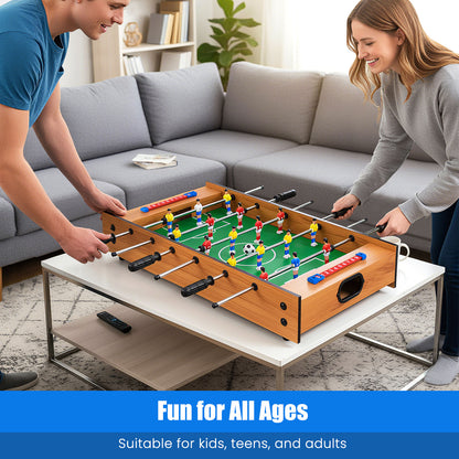 An adult man and woman playing a foosball match on the game board in a living room setting
