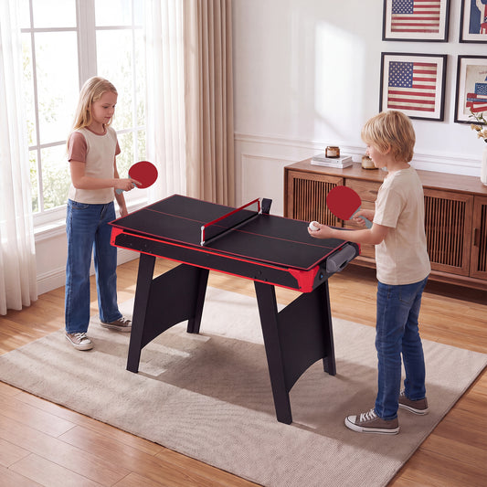 Children playing table tennis on the multi-game table in a living room