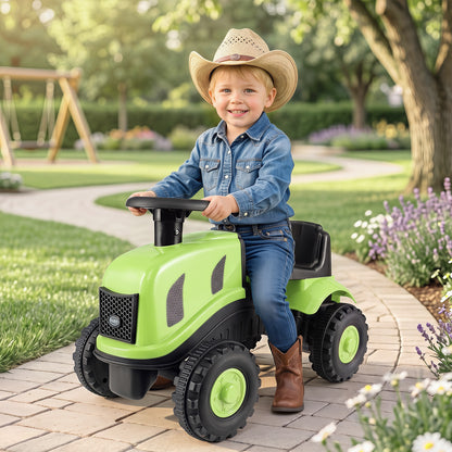 A child sits on the green ride on tractor with trailer in a garden setting
