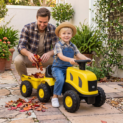 The yellow ride on toy being used by a child to carry autumn leaves in the garden