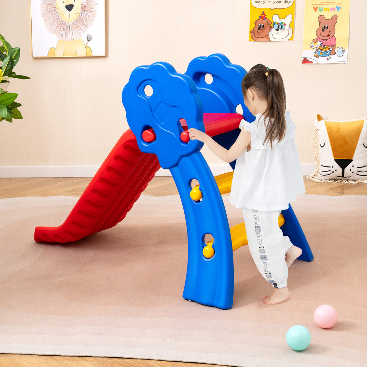 Child climbing the steps of the red and blue slide