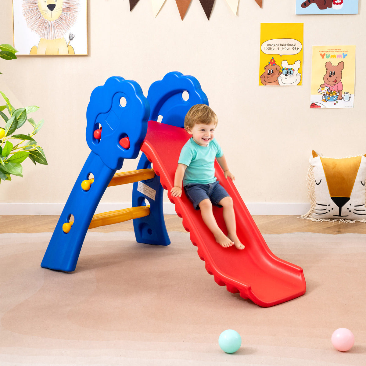 Toddler sliding down the red slide indoors