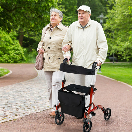 Elderly couple walking with the red mobility aid in a park