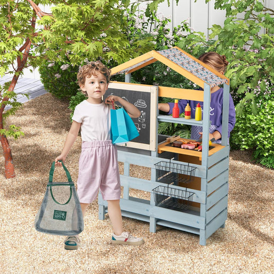 Children playing at the wooden mud kitchen and grocery store in a garden