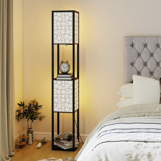 The floor lamp with shelves next to a bed, with books and headphones on the shelves
