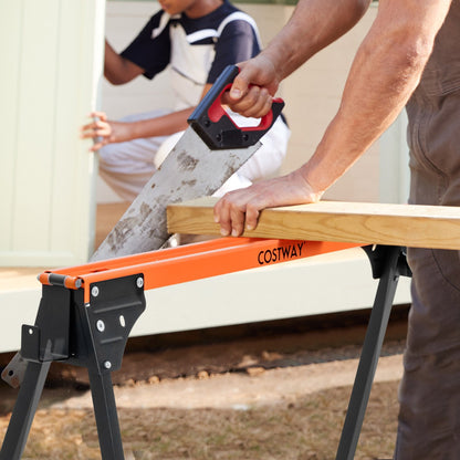 Close up of a person sawing a wooden plank resting on an orange and black portable saw horse work table
