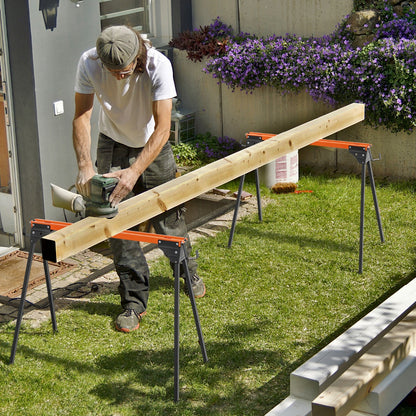 Man sanding a wooden beam supported by two orange and black portable saw horse work tables in a garden
