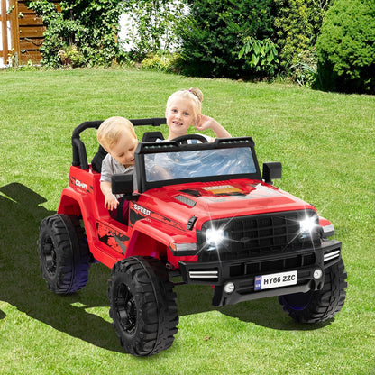 Two young children enjoying a ride in the red electric car on a sunny lawn