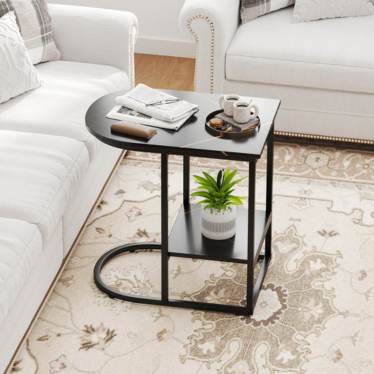 The modern sofa side table with a black marble effect top placed next to a sofa with a plant and newspaper on it