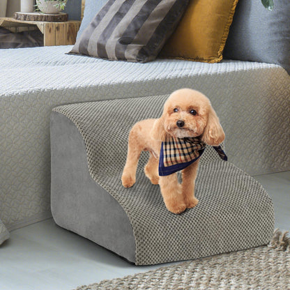 The pet stairs placed beside a bed with a small dog wearing a scarf standing on top