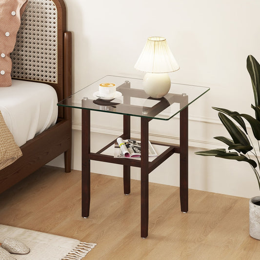 The end table in a bedroom setting with a lamp and books on the shelf