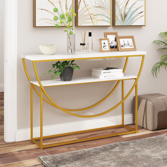 The console table placed against a wall in a living room with pictures and a plant on top